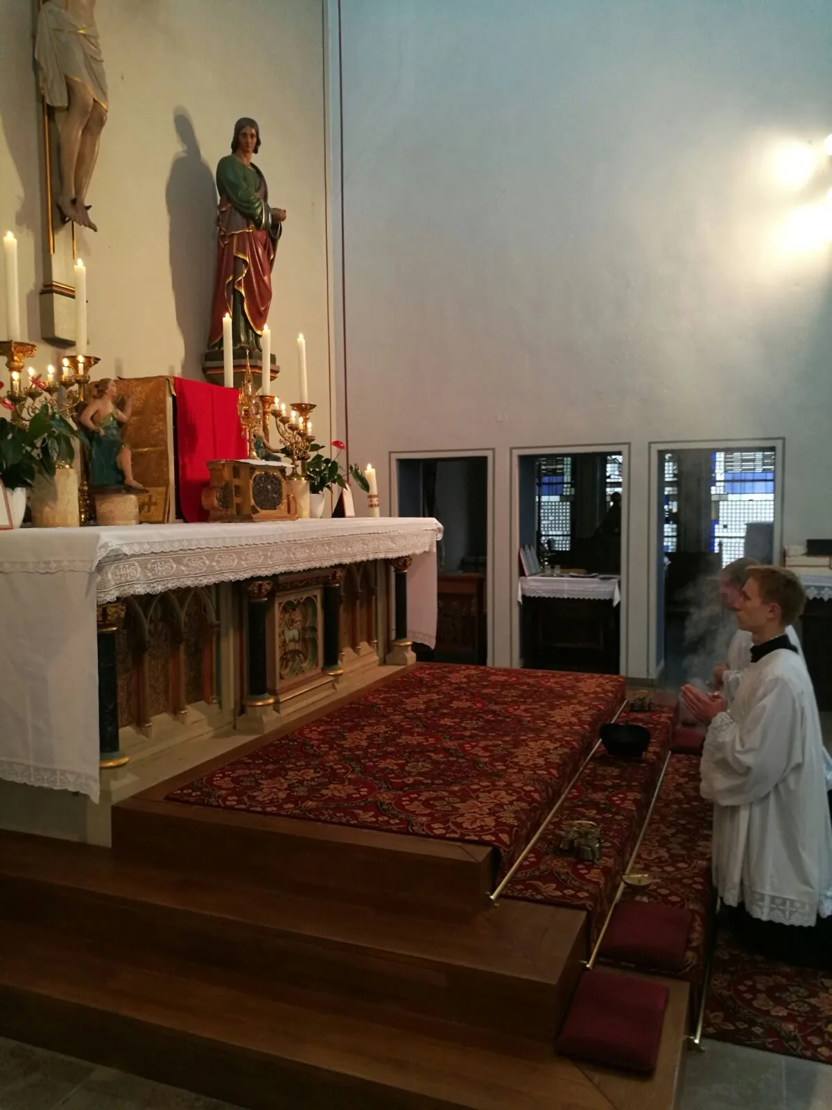 Kleiner Ministrant kniet vor dem Altar